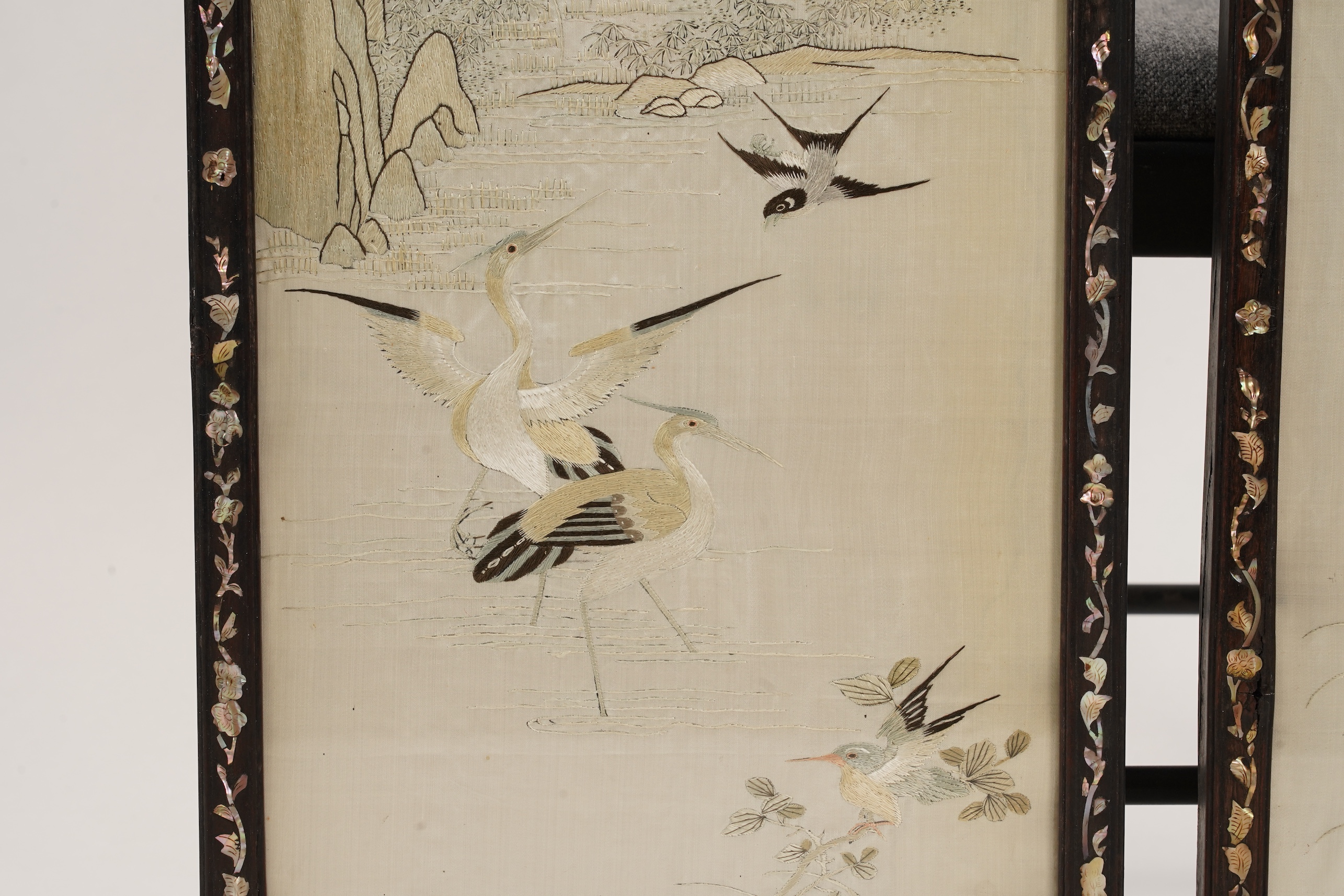 A pair of Chinese embroidered silk ‘bird’ panels, in mother-of-pearl inlaid hongmu frames, late 19th/early 20th century